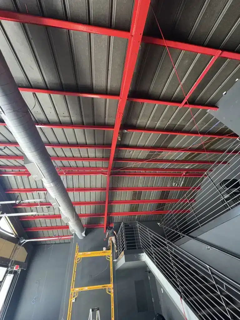 Commercial ceiling with steel beams painted red — MG Barillas Painting