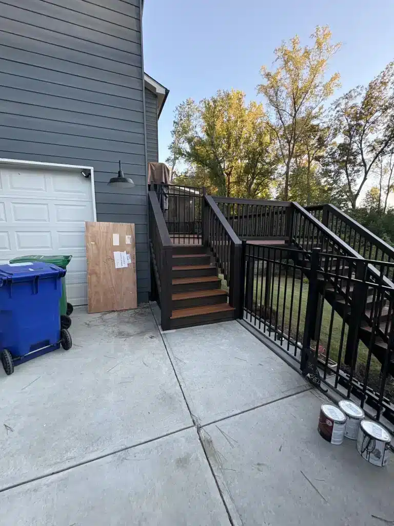 Exterior stairs with black railings and painted garage door — MG Barillas Painting
