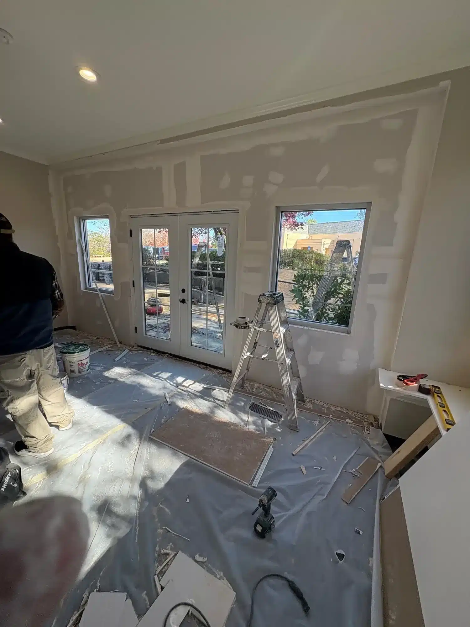 Before: Family room drywall patched and primed with floors protected