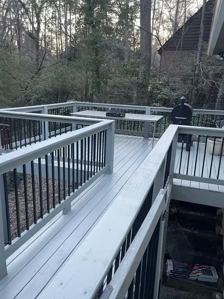 Gray painted deck with black railings on a wooded lot — MG Barillas Painting