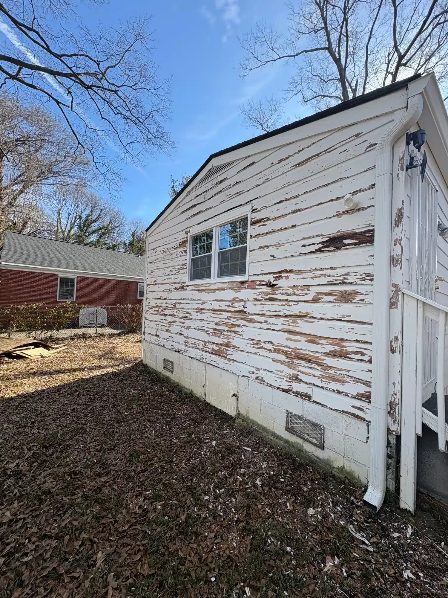 Before: Lap siding with badly peeling paint before scraping and repainting