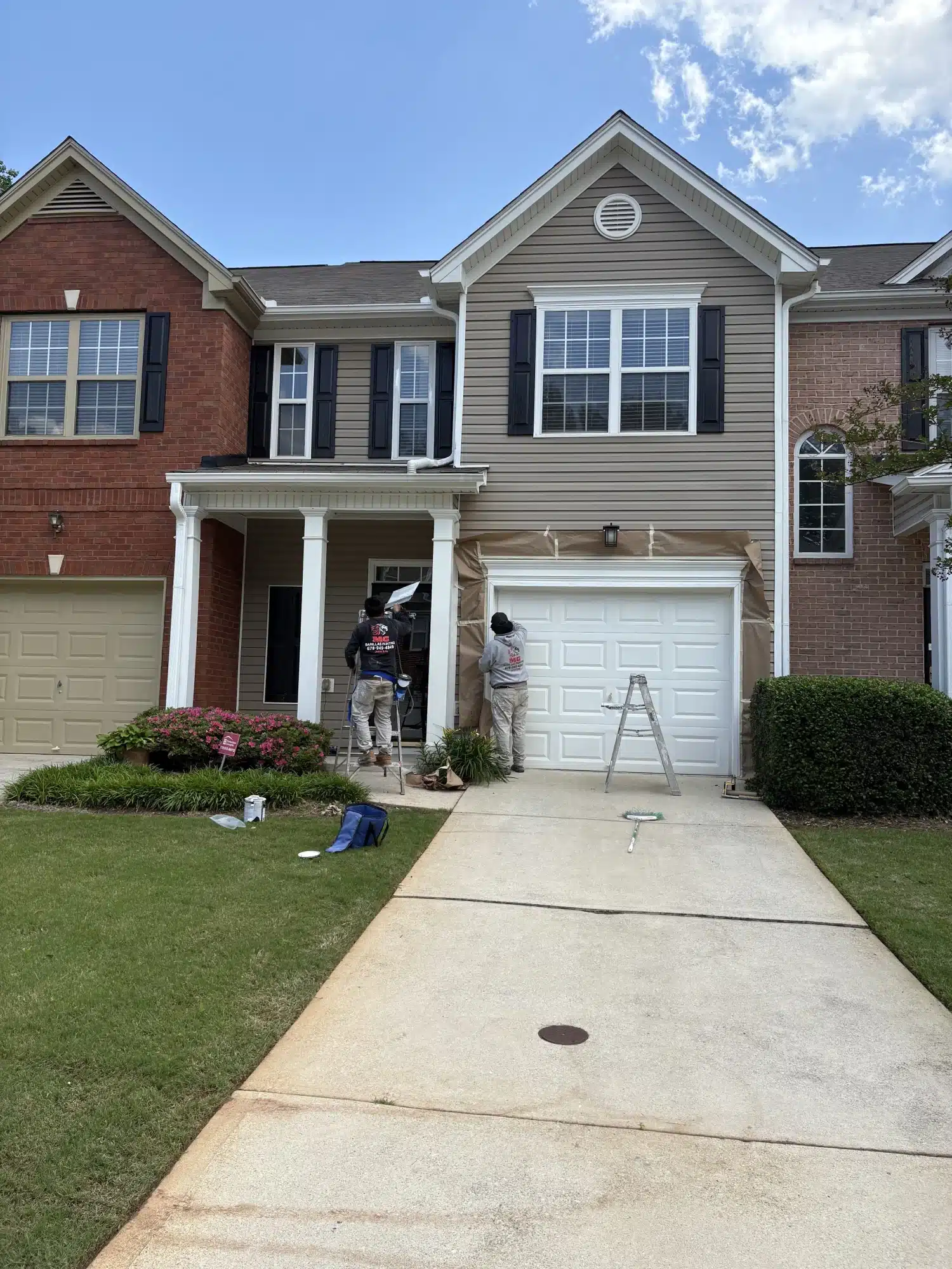 MG Barillas crew painting the front of a brick and siding townhome — MG Barillas Painting