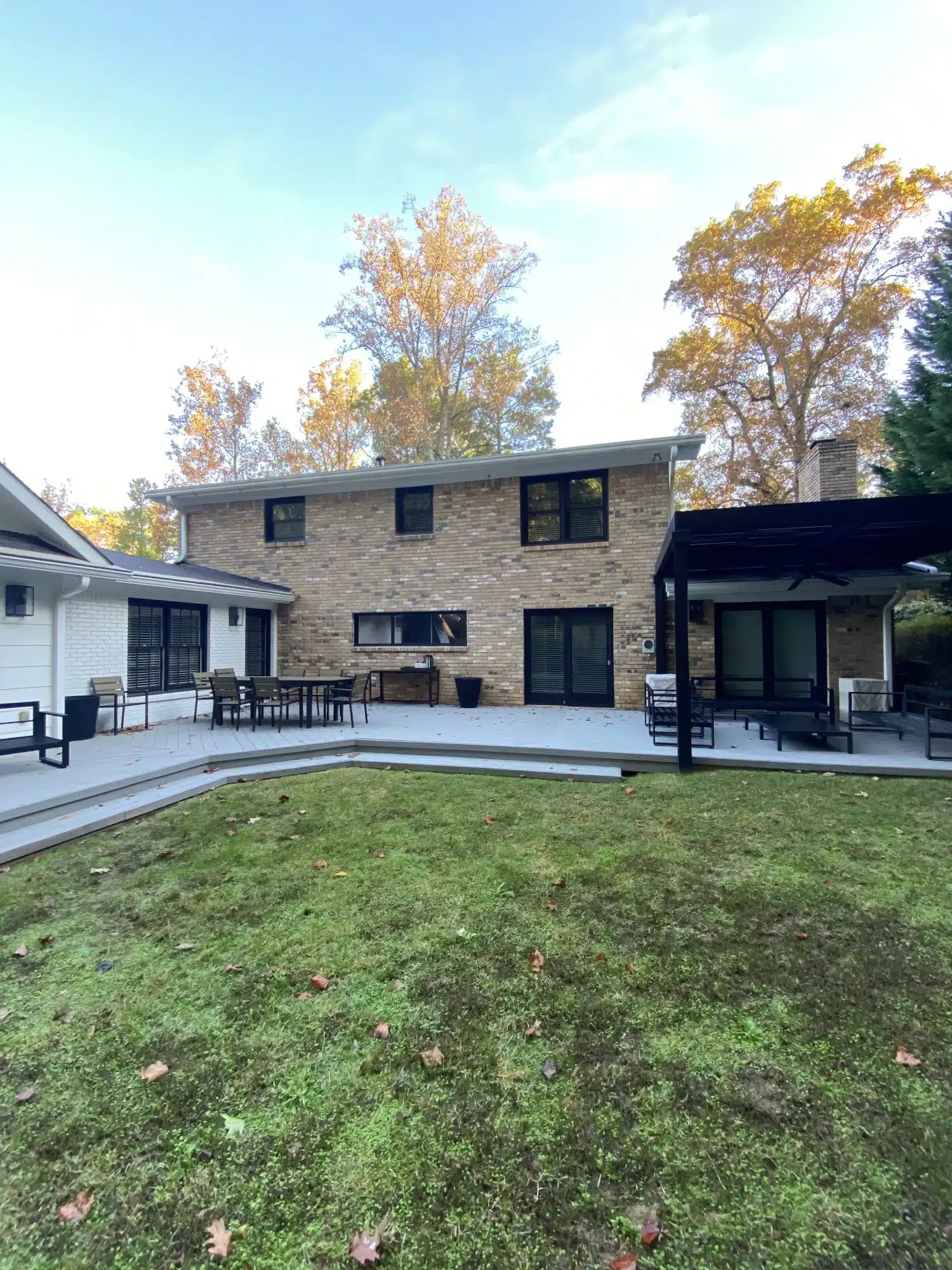 Painted brick two-story home and patio seen from the back yard — MG Barillas Painting