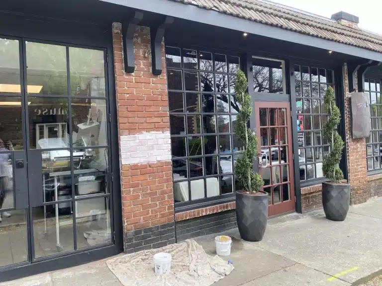 Restaurant storefront with black window frames and painted brick — MG Barillas Painting