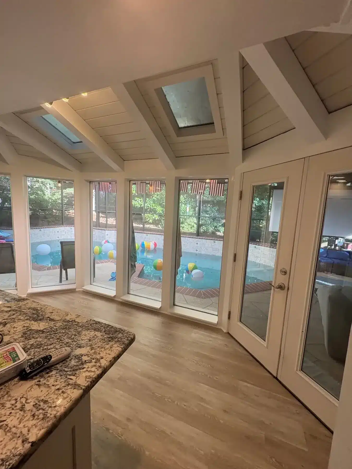 After: Sunroom with beams, trim and windows painted white