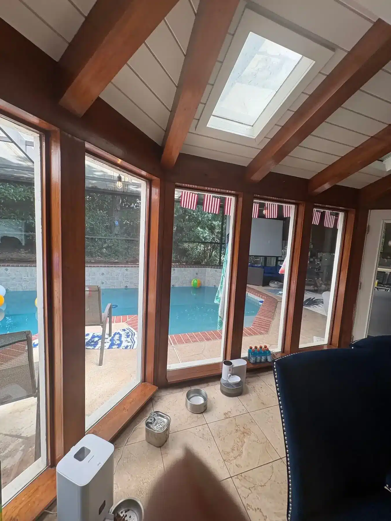 Before: Sunroom with dark stained beams and trim before painting
