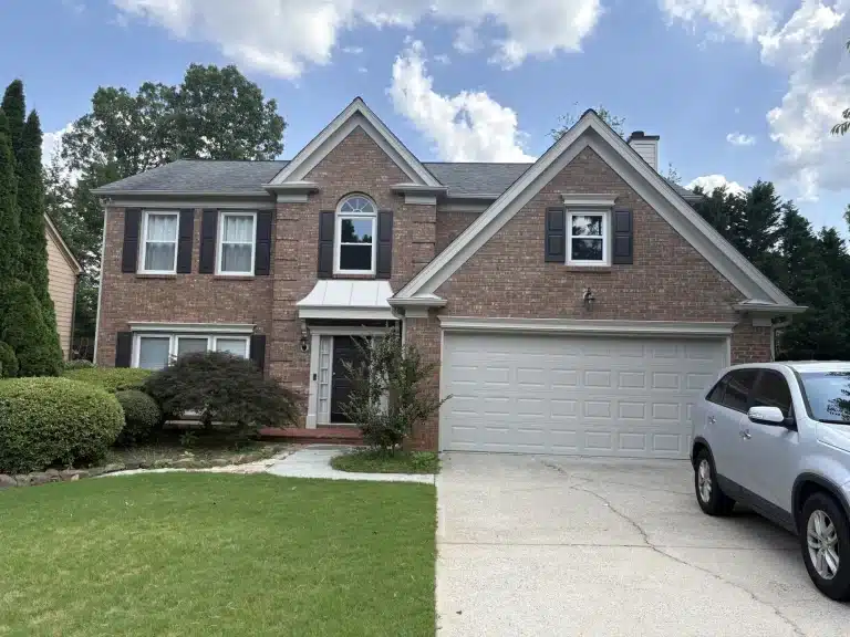 Two-story brick home with freshly painted trim and garage door — MG Barillas Painting
