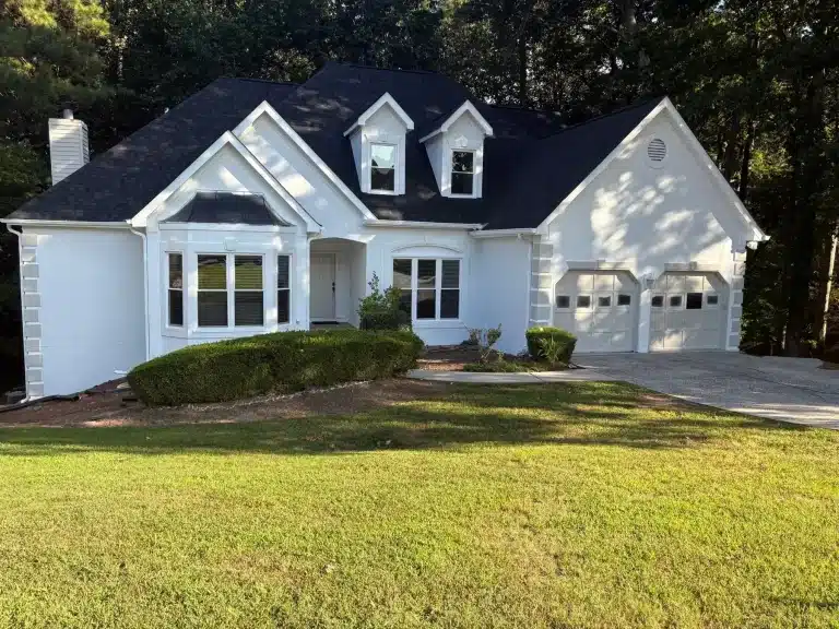 White stucco home with fresh exterior paint and a black roof — MG Barillas Painting