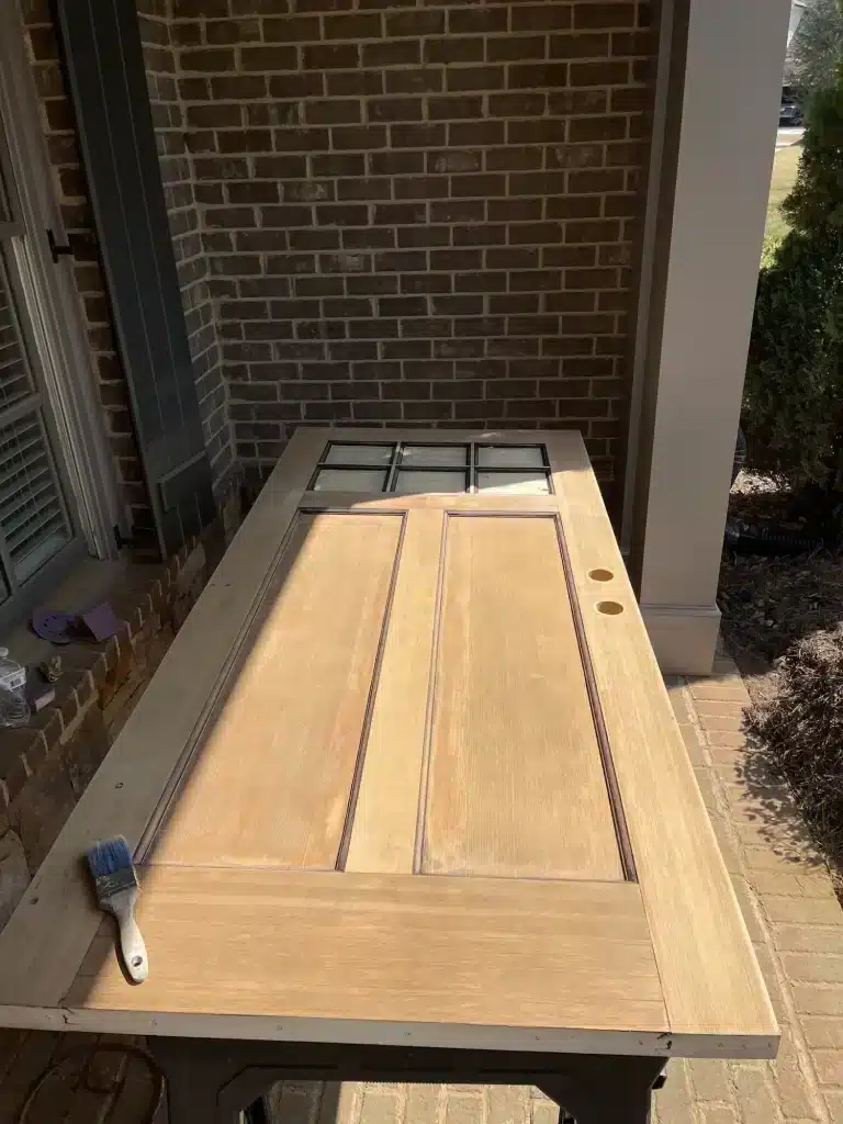 Wood door being refinished on sawhorses — MG Barillas Painting